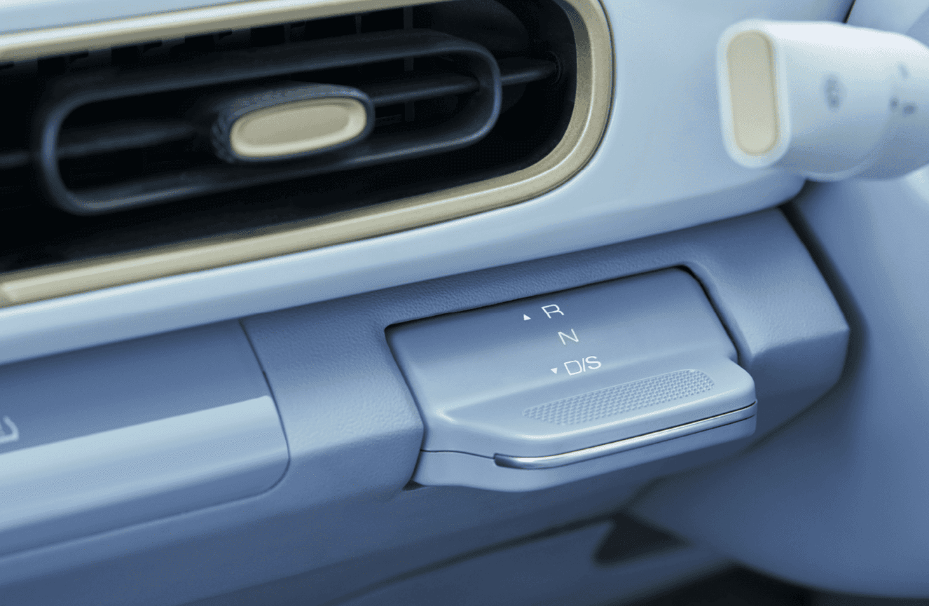 Tuas transmisi elektrik bergaya minimalis dengan pengoperasian sederhana, menghadirkan perpindahan mode berkendara yang halus sekaligus menambah kesan futuristik pada interior kendaraan.