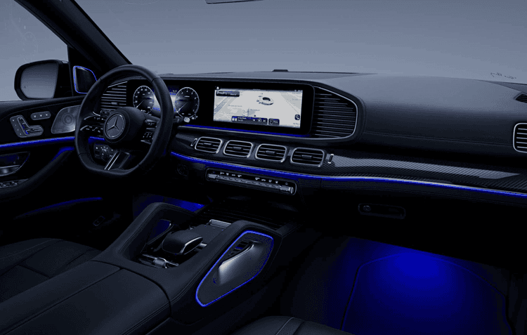 Kabin Mercedes-Benz GLS menampilkan desain modern dan elegan. Layar ganda widescreen terintegrasi dengan sistem MBUX. Pencahayaan ambient biru memberi kesan mewah.