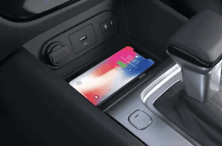 Area konsol tengah dilengkapi wireless charger dan port USB. Anda bisa mengisi daya smartphone tanpa kabel. Posisi dekat tuas transmisi memudahkan akses saat berkendara.